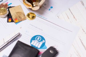 Credit Bureau Reports Close-up of financial documents, credit cards, coins, and a pen on a wooden desk.